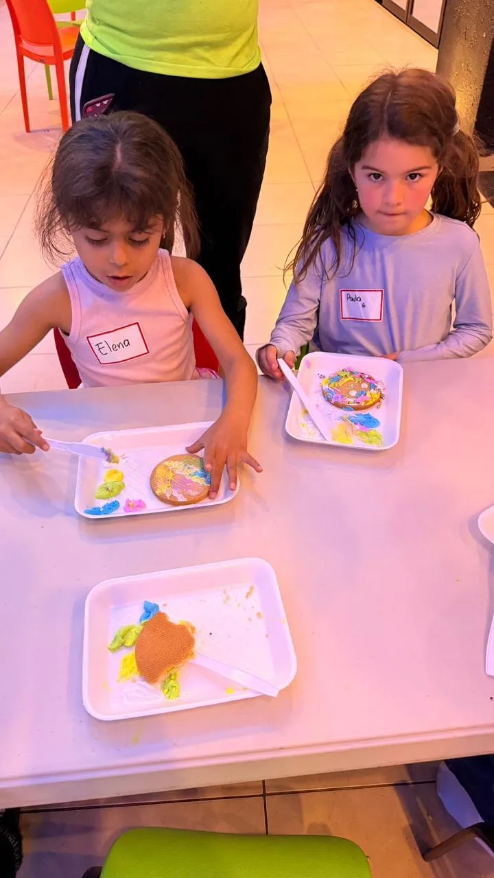 Niñas decorando galletas en el campamento Kidiverso