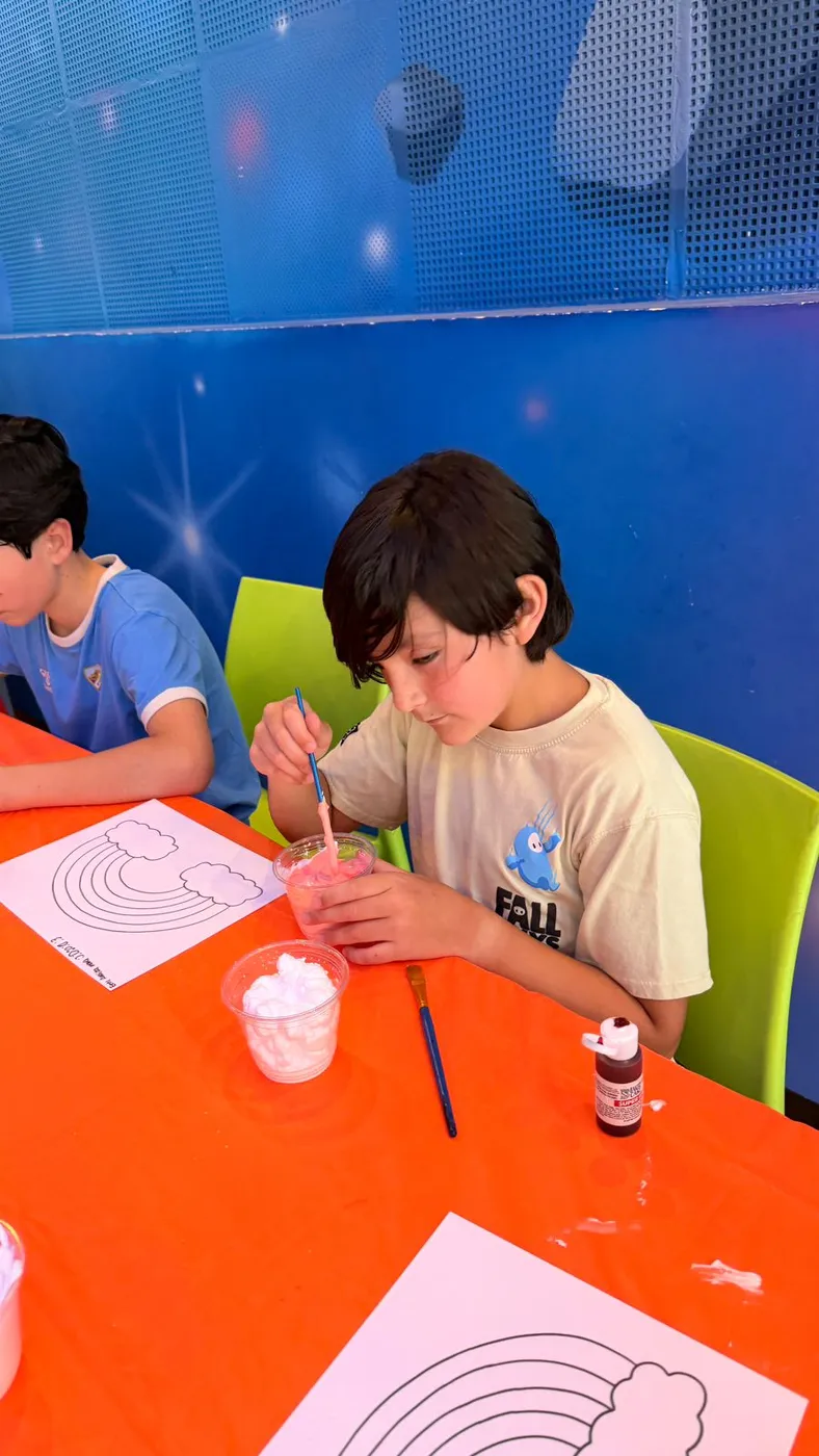 Niño pintando un dibujo en el campamento Kidiverso